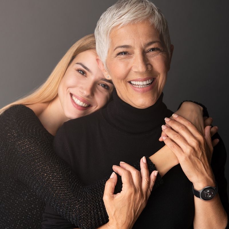 Two women embracing each other against a dark background