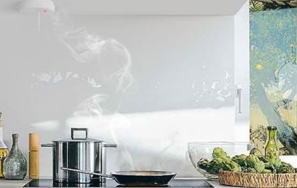 Kitchen scene with a pot on the stove and a glass splashback